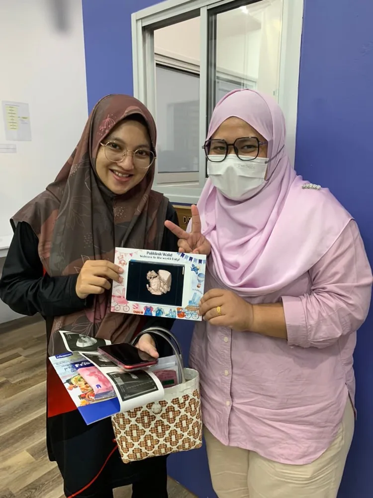 Clinic staff holding a pregnancy ultrasound image